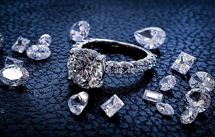 A diamond ring surrounded by other diamonds of various shapes