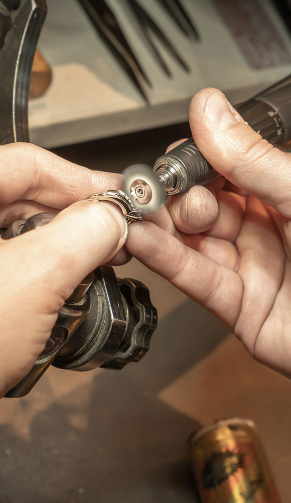 a ring being worked on by a jeweler with a hand tool